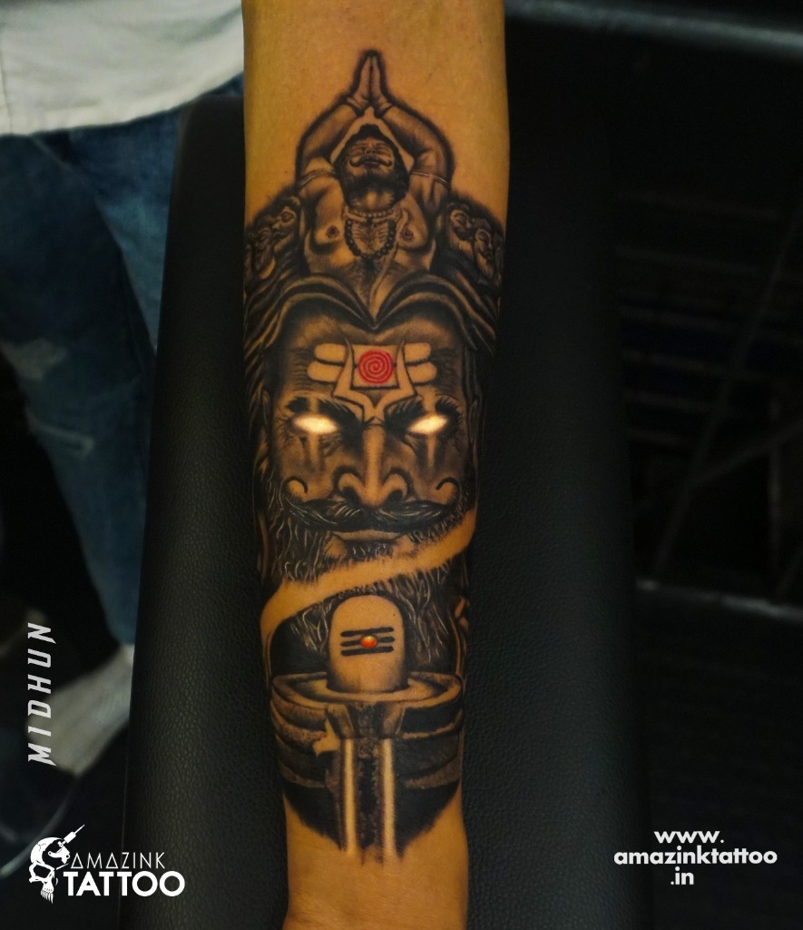 Divine Lord Shiva portrait with a Shiva Lingam forearm tattoo in spiritual black and grey, custom designed and inked by Midhun at Amazing Tattoo, Calicut, Kerala.